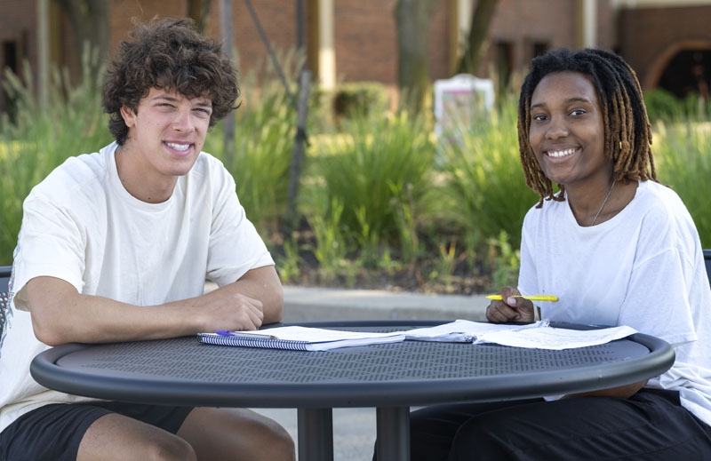 Two macomb students doing homework on center campus.