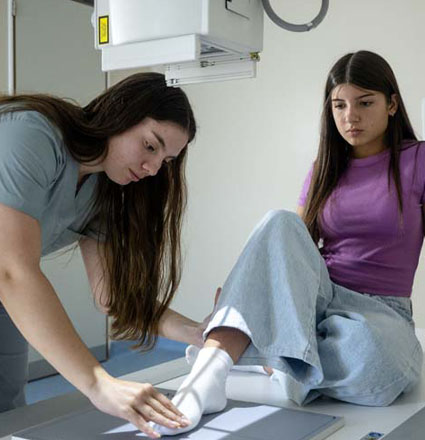 Macomb student examines a girl's ankle.