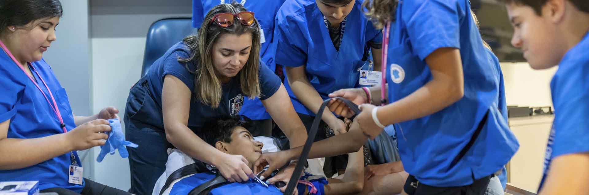 Students from 2023 Camp Scrubs pratice what they've learned in the back of an ambulance.